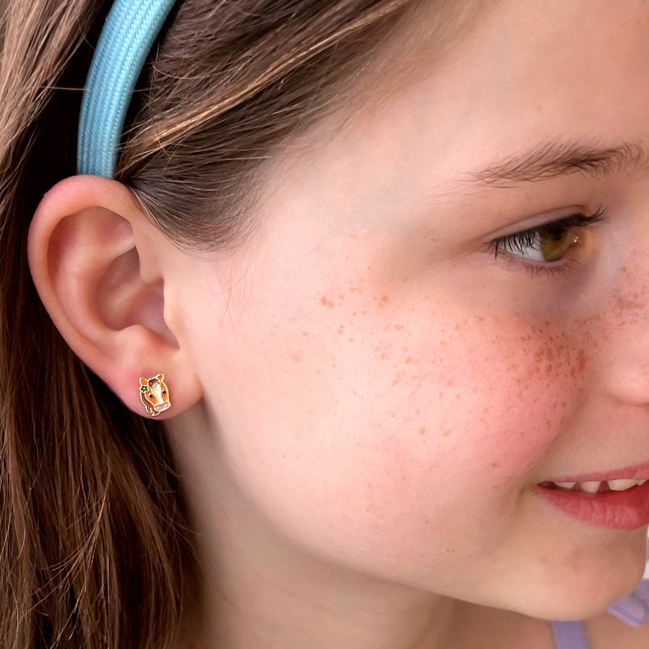 Macro view of the pony stud design highlighting the high-quality enamel and secure stay-on back. Irritation-free and durable for active children's daily play.