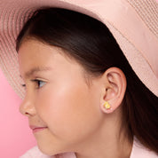 Close-up of transparent silicone clip-on earring on child's earlobe, invisible fit