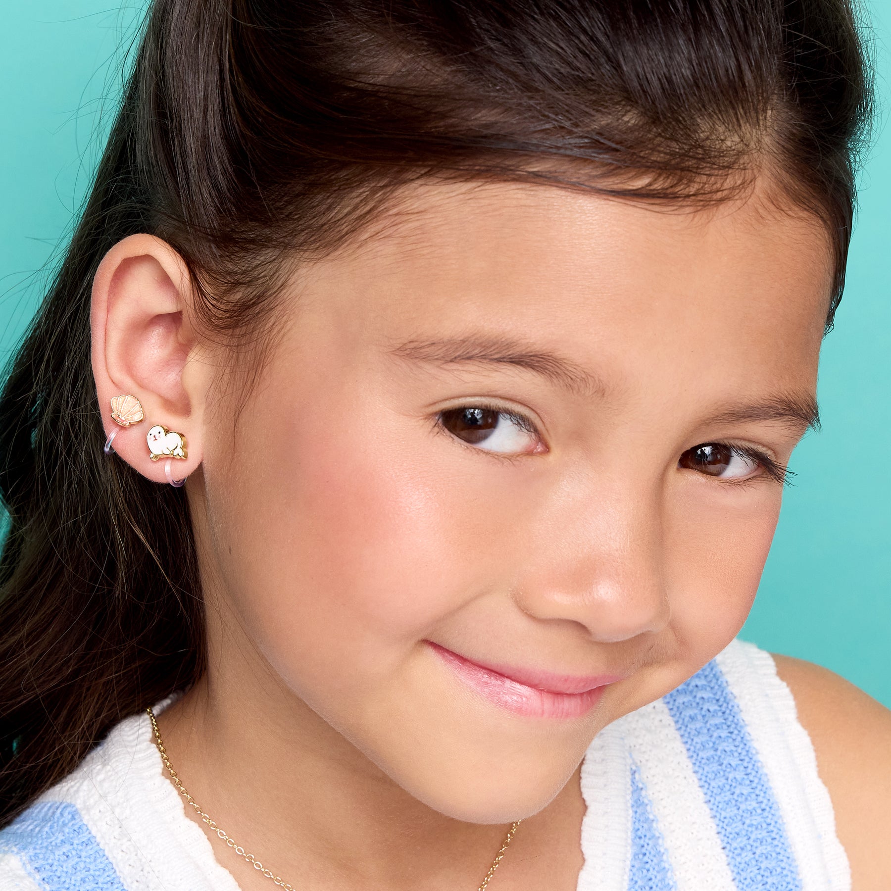 Young girl wearing pain-free seal clip-on earrings by Girl Nation Canada