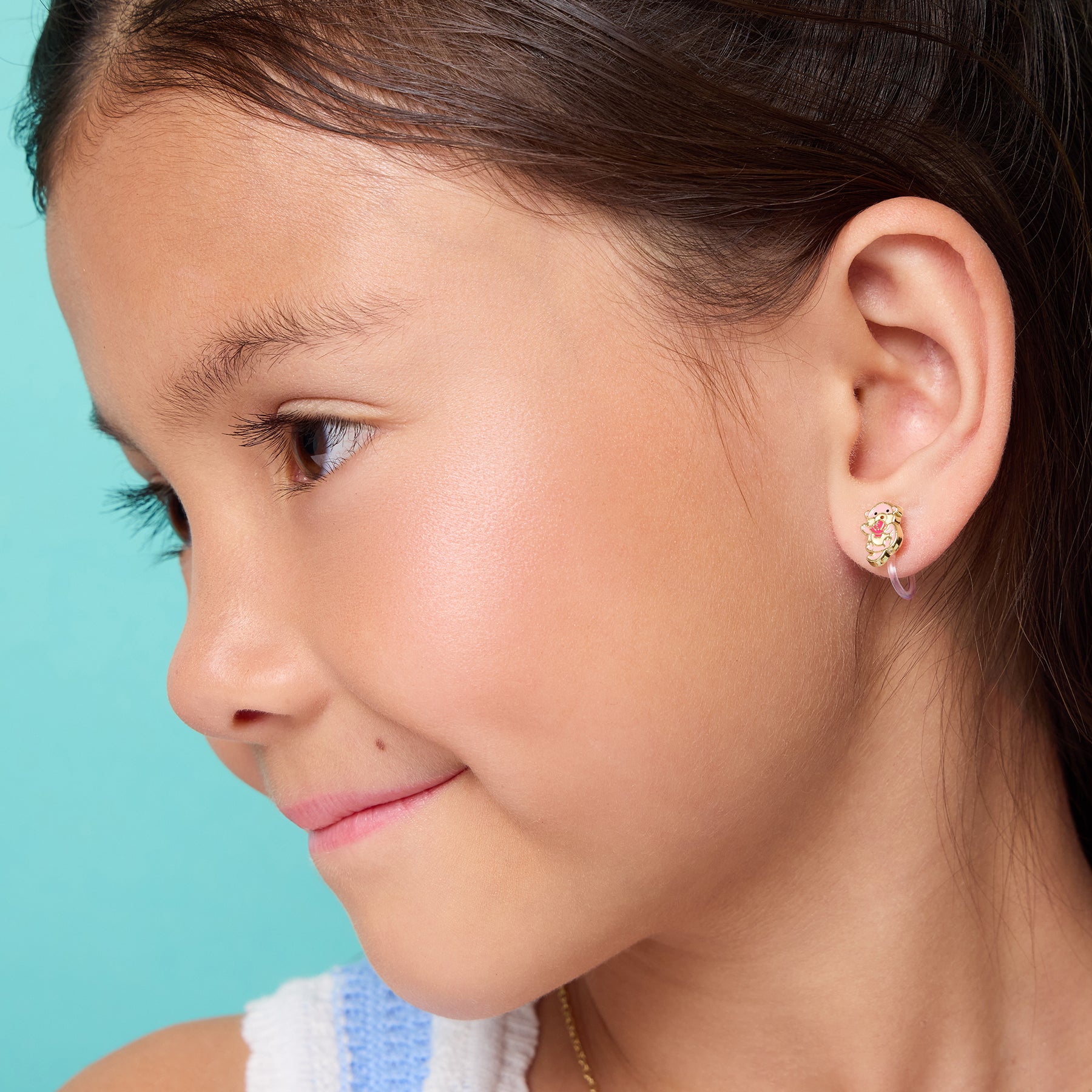 Young girl wearing pain-free otter clip-on earrings by Girl Nation Canada