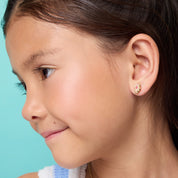 Young girl wearing hypoallergenic otter stud earrings by Girl Nation Canada