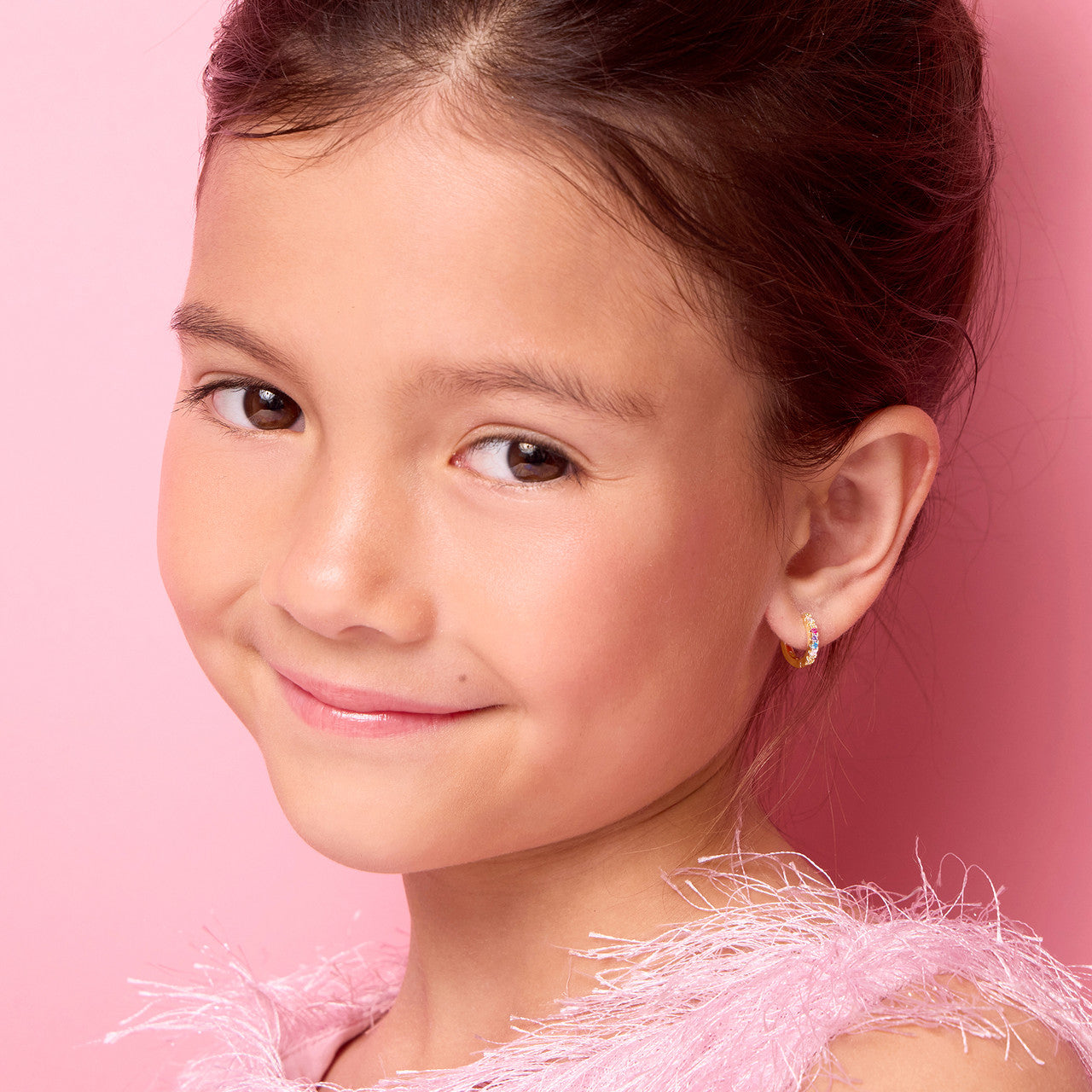 Young girl wearing 18K gold plated multi-colored CZ huggie earrings by Girl Nation Canada