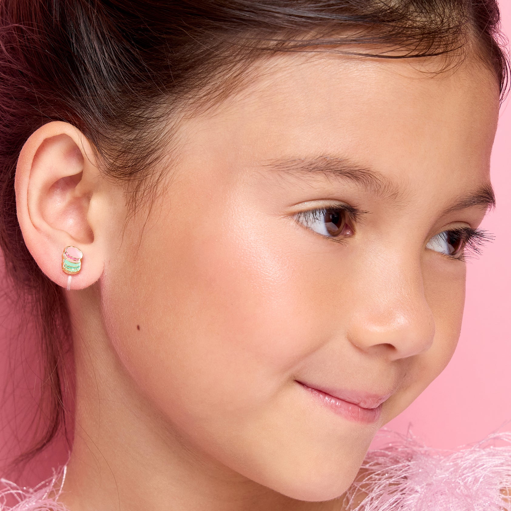  Close-up of transparent silicone clip-on earring on child's earlobe, invisible fit
