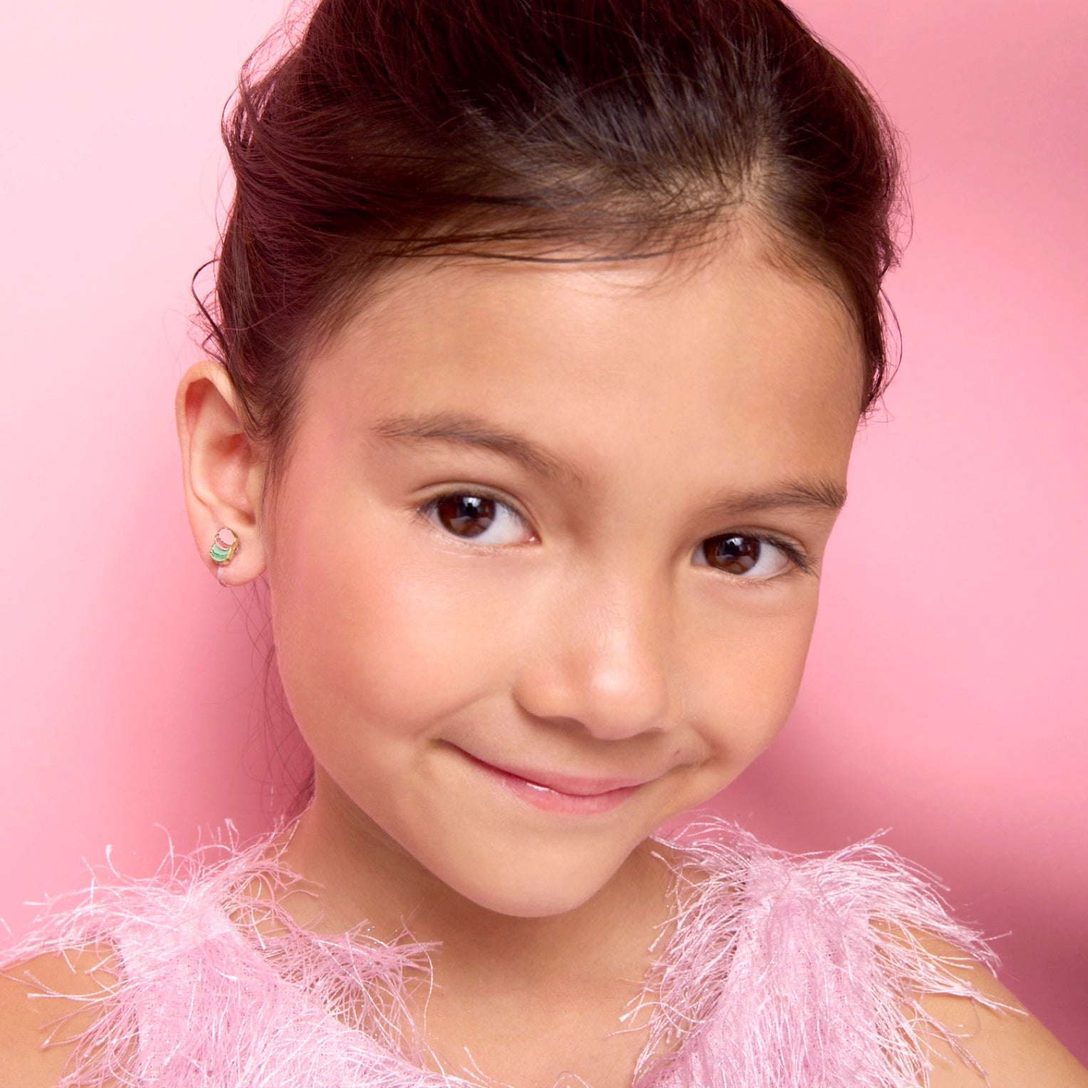 Young girl wearing pain-free macaron clip-on earrings by Girl Nation Canada