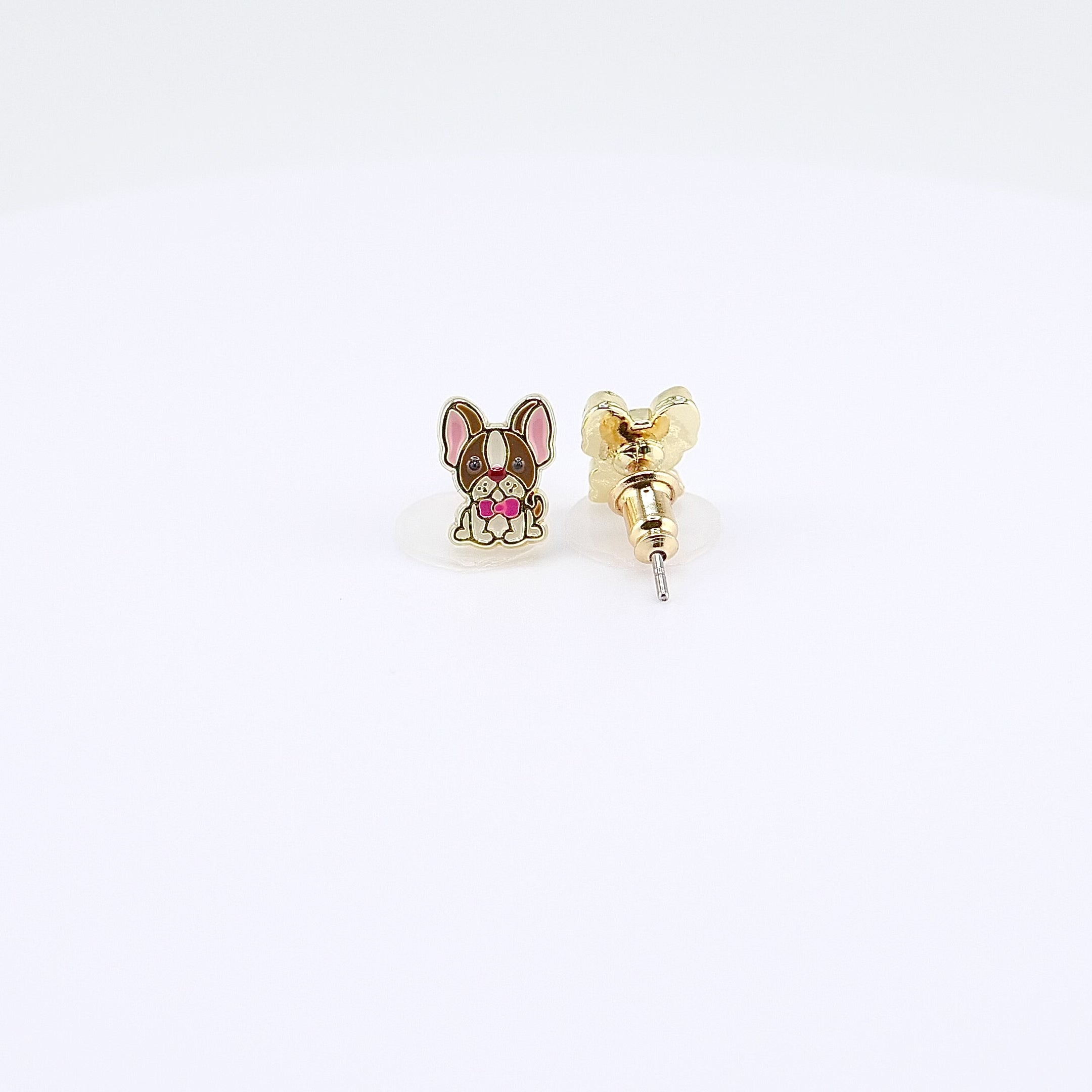 French Bulldog stud earrings with pink bow tie rotating on display, video