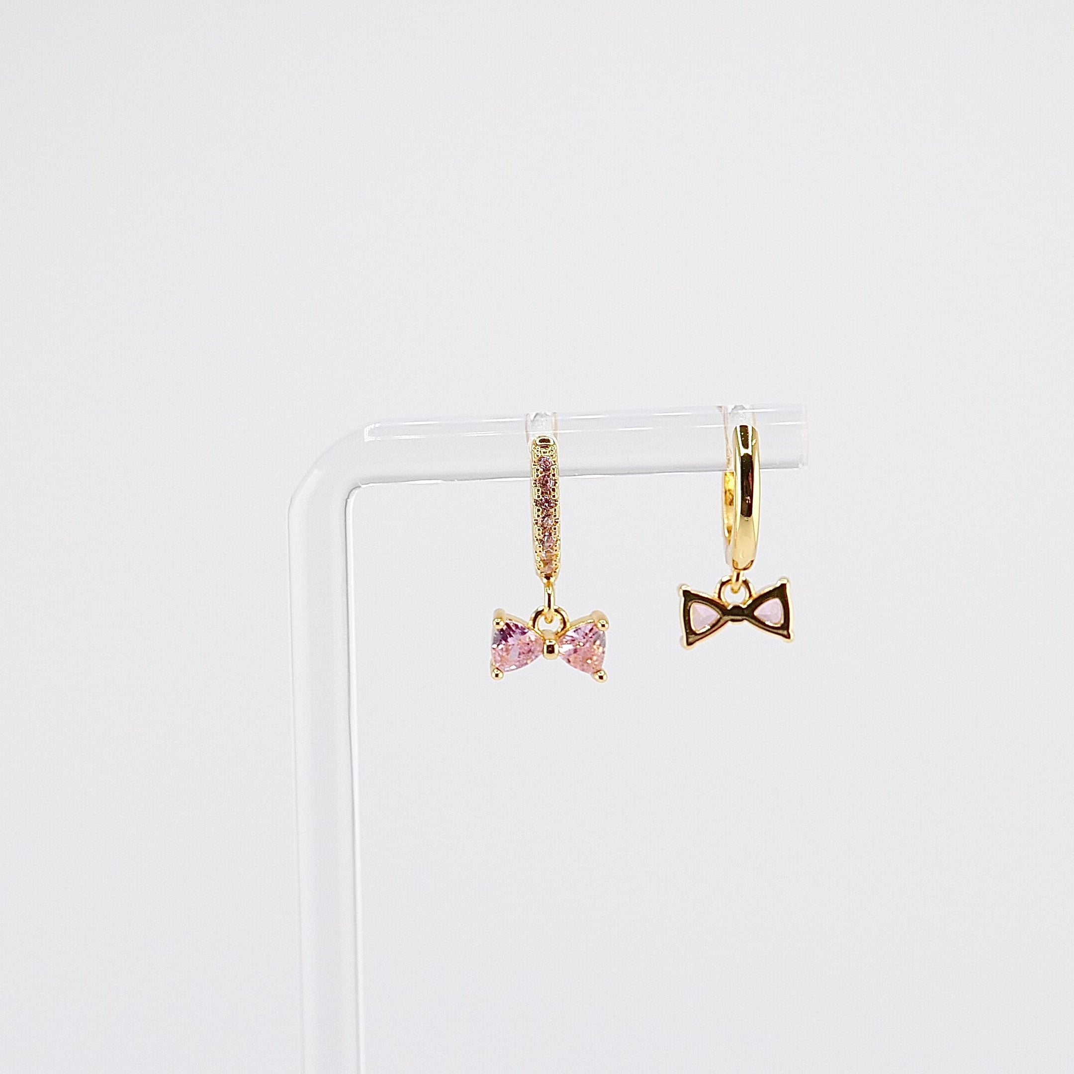 18K gold plated pink bow charm huggie earrings rotating on display, video
