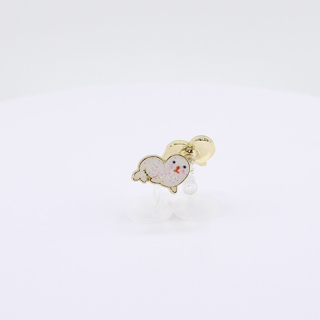 Glittery white seal charm clip-on earrings rotating on display, video
