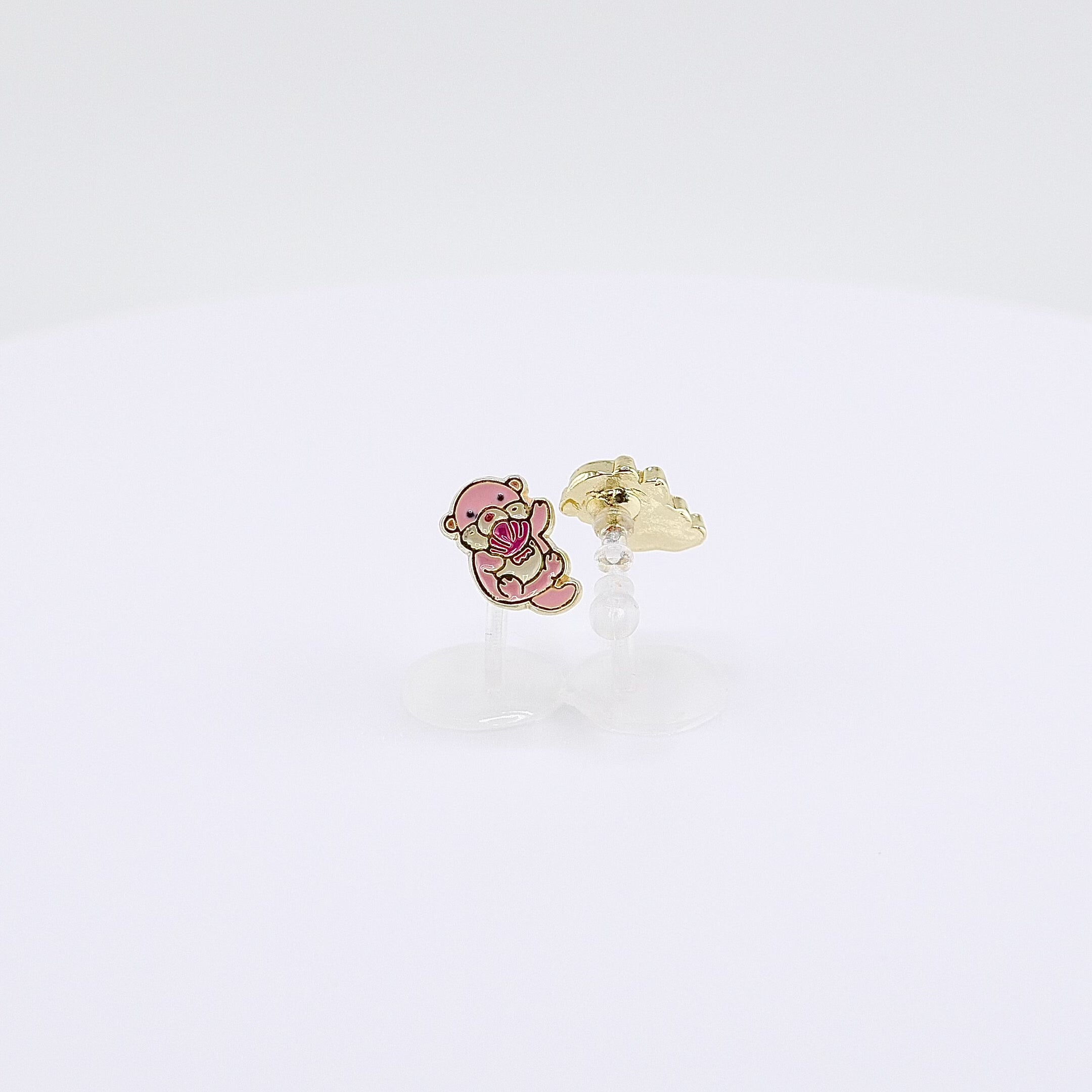  Pink otter charm clip-on earrings holding a shell, rotating on display, video